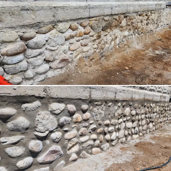 Fieldstone foundation before and after repointing: eroded joints and loose stones above, rebuilt mortar joints below
